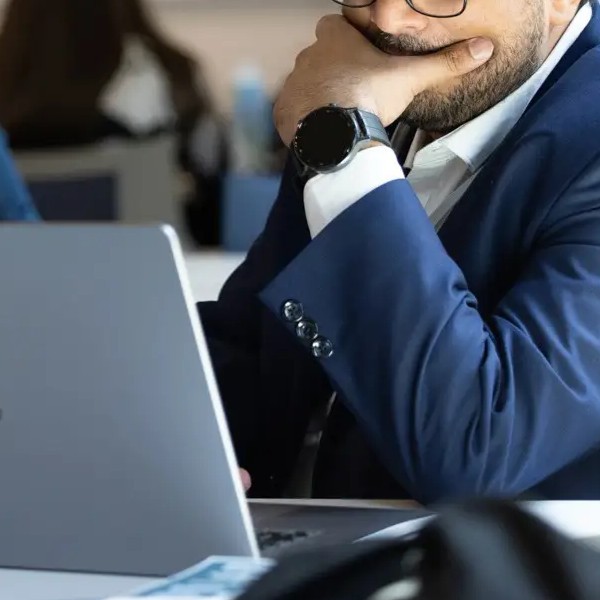 Close up of a man concentrating hard while working on a laptop